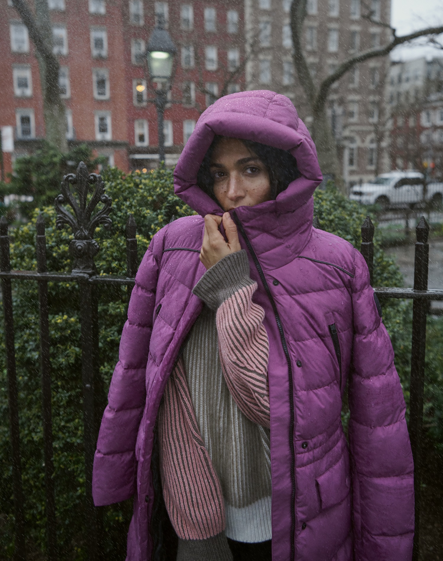Frau hüllt sich in einen violetten Woolrich Daunenmantel